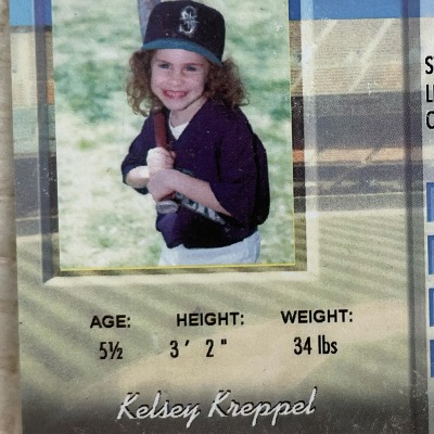 Childhood picture of Kelsey Kreppel holding a baseball bat.
